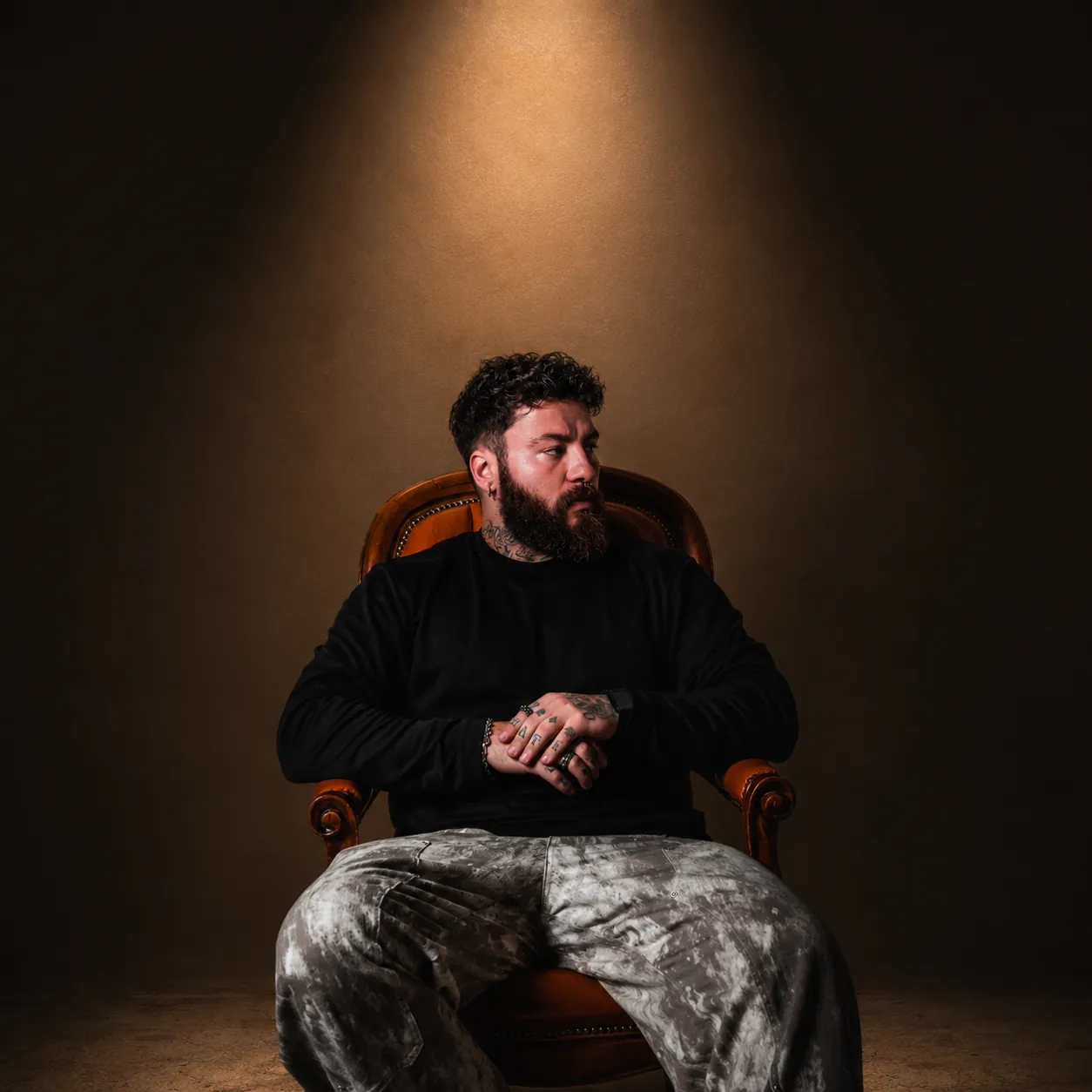 Portrait von HYPEVISION im Ledersessel unter einem Spotlicht
